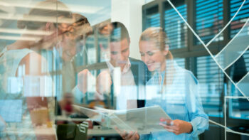 Business Team looking at folder behind glass